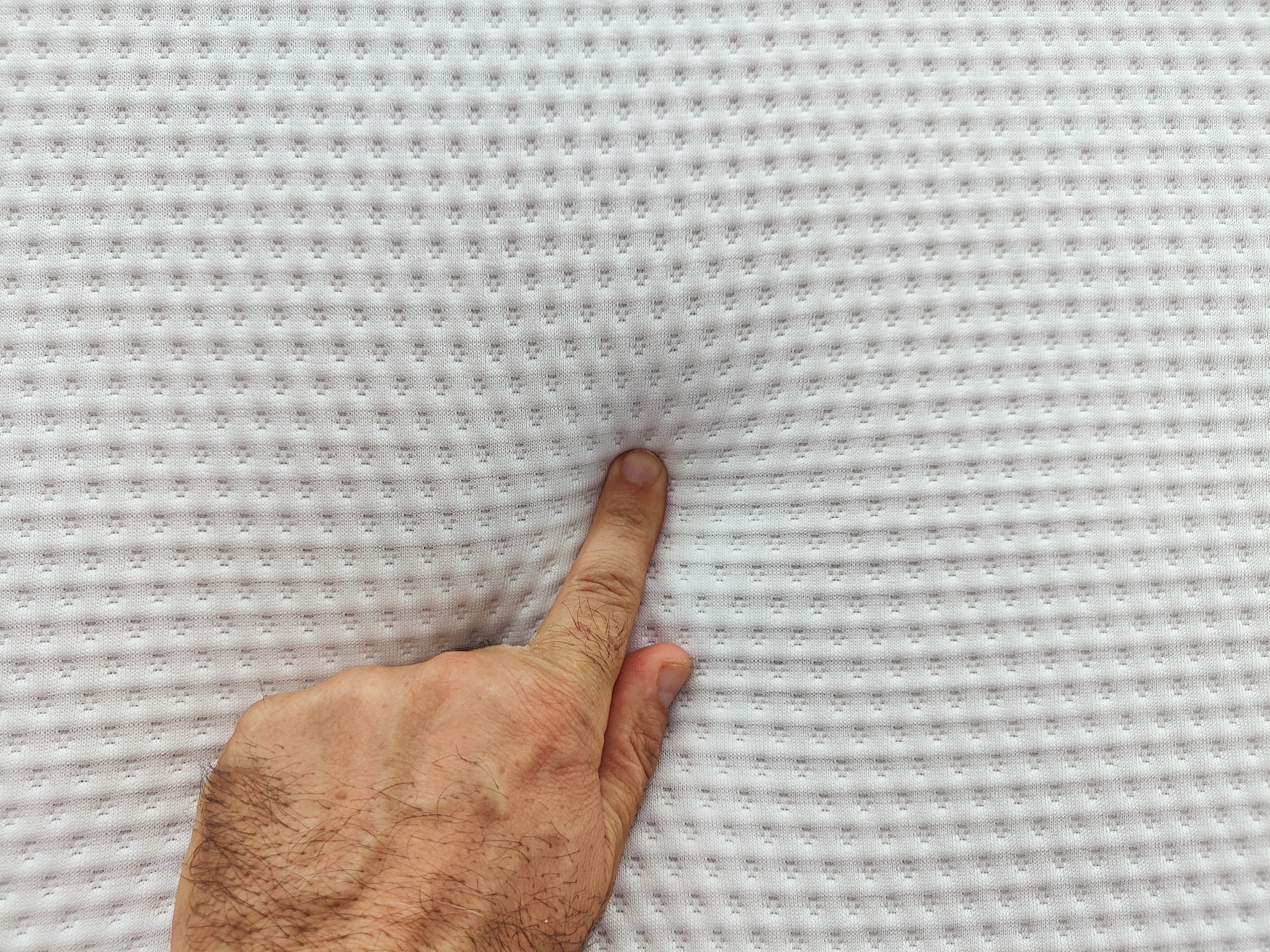 male hand on memory foam mattress